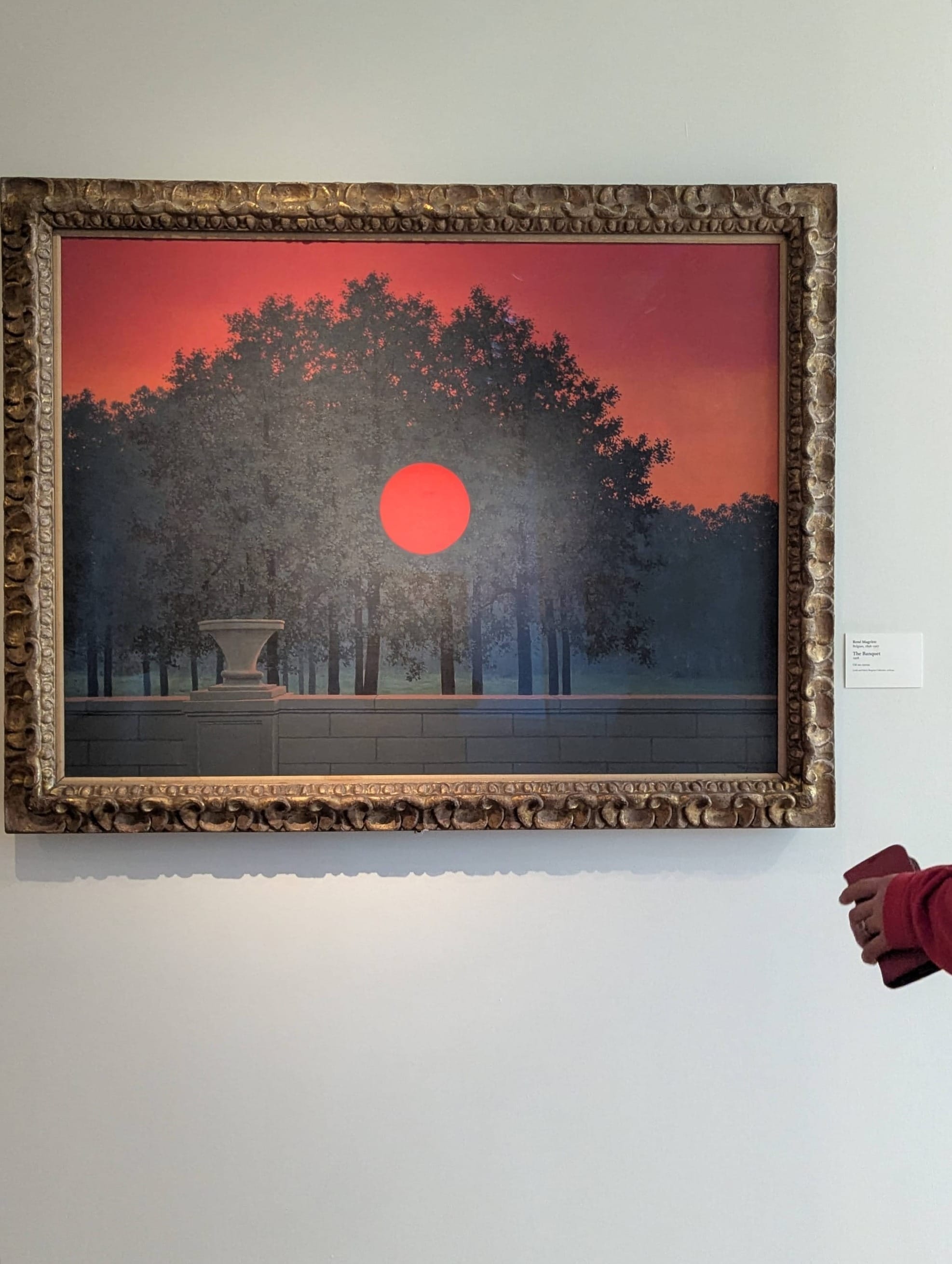 a photo of Rene Magritte's "The Banquet" on display at AIC; it's a painting of a tree-lined landscape with a striking red dot at the center